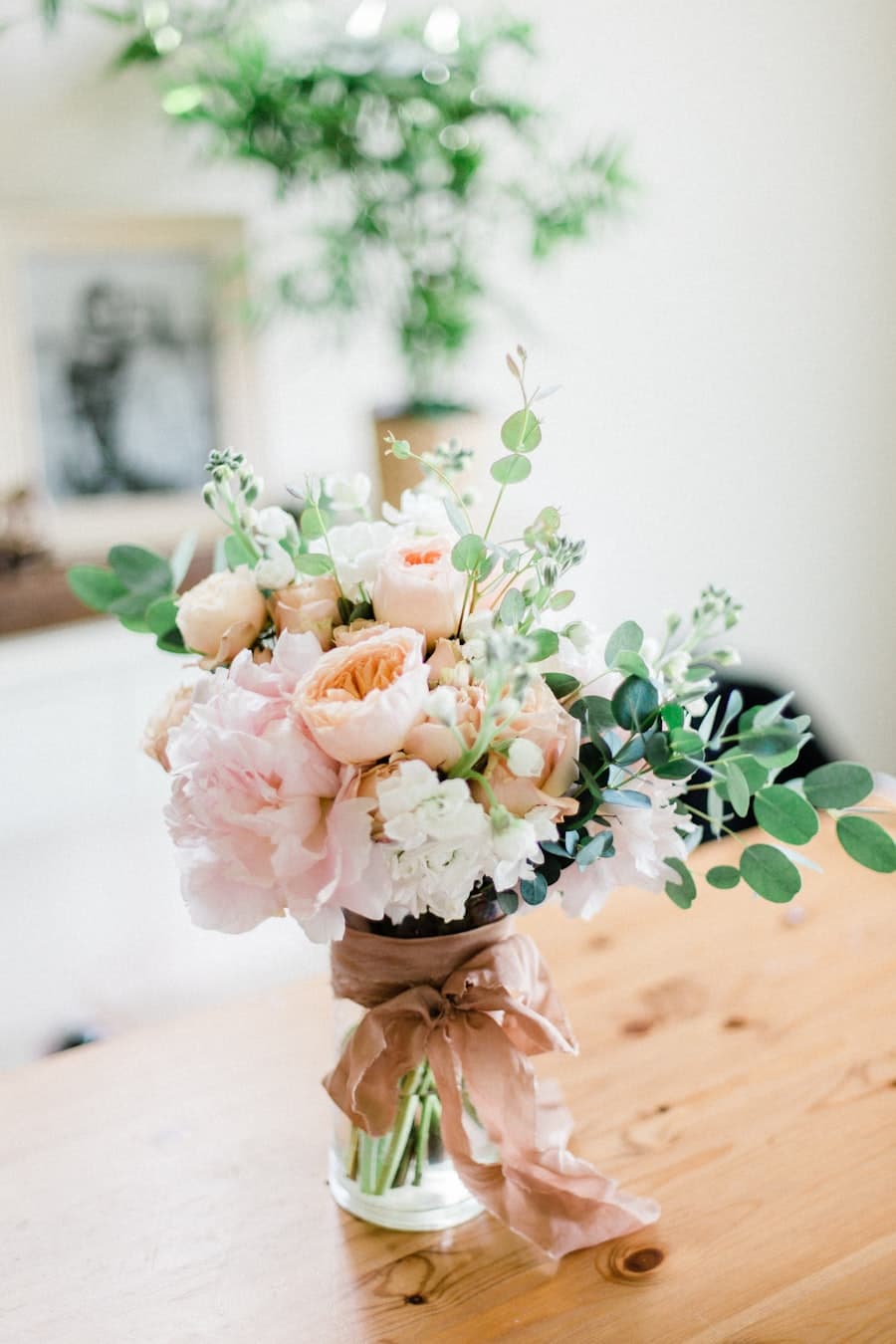 Peach garden roses and eucalyptus in a glass vase