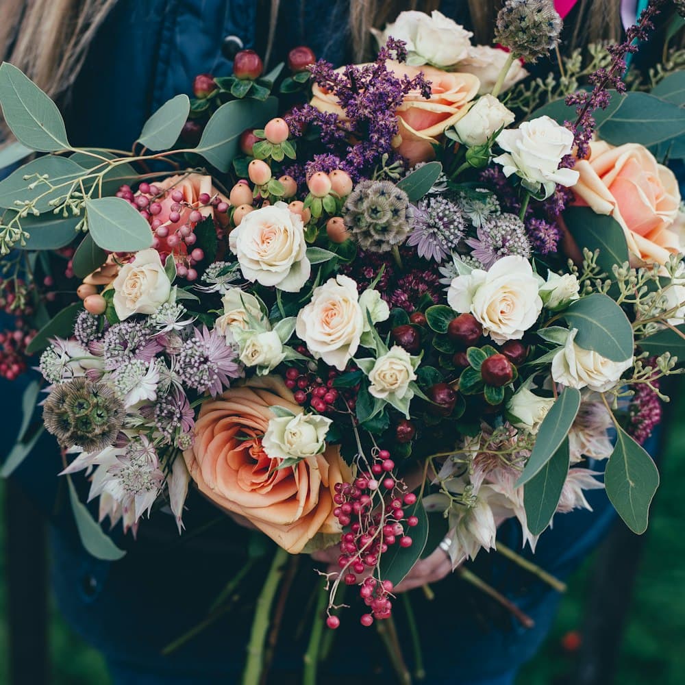 Peach roses, berries, and eucalyptus